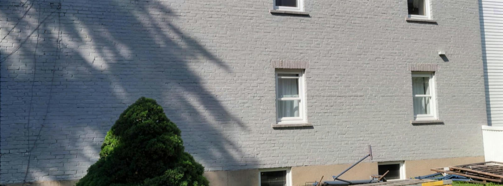 Mur de brique d'un immeuble à logements repeint en gris