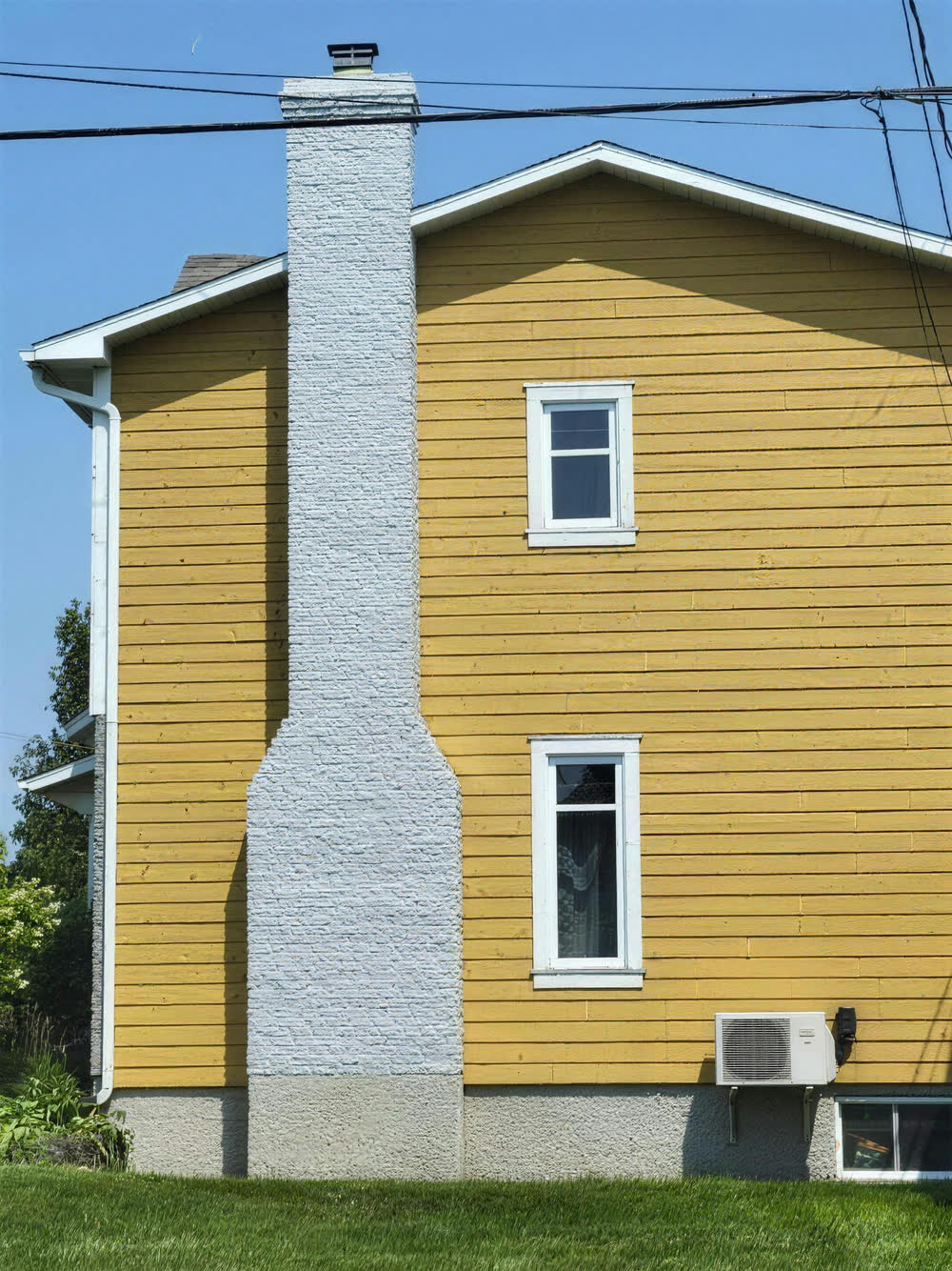 Maison au revêtement jaune et cheminée grise repeinte